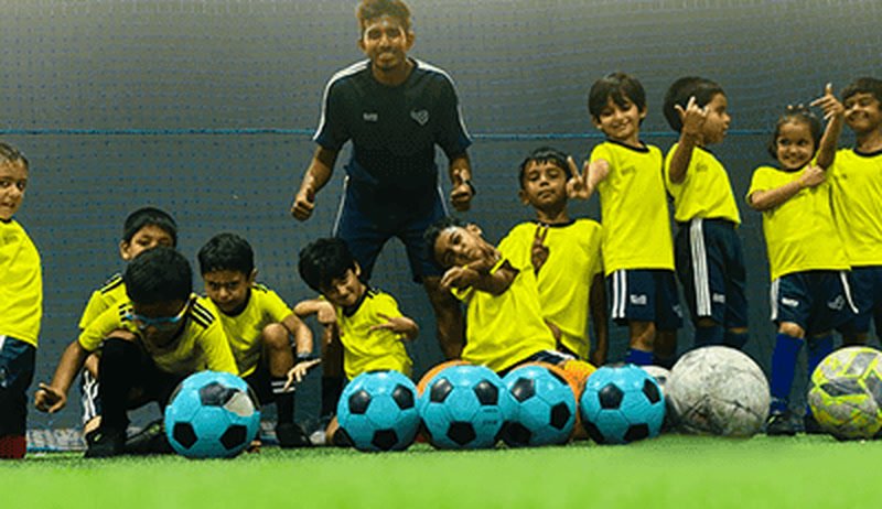 ESSB football coach training a group of children